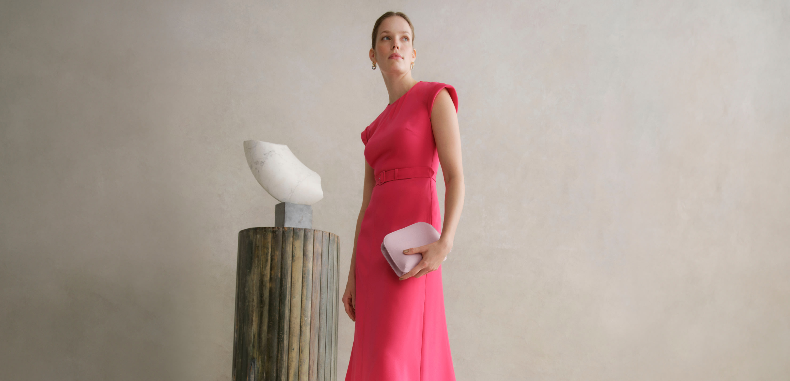 Image of a model wearing a pink midi dress with coordinating occasion accessories.