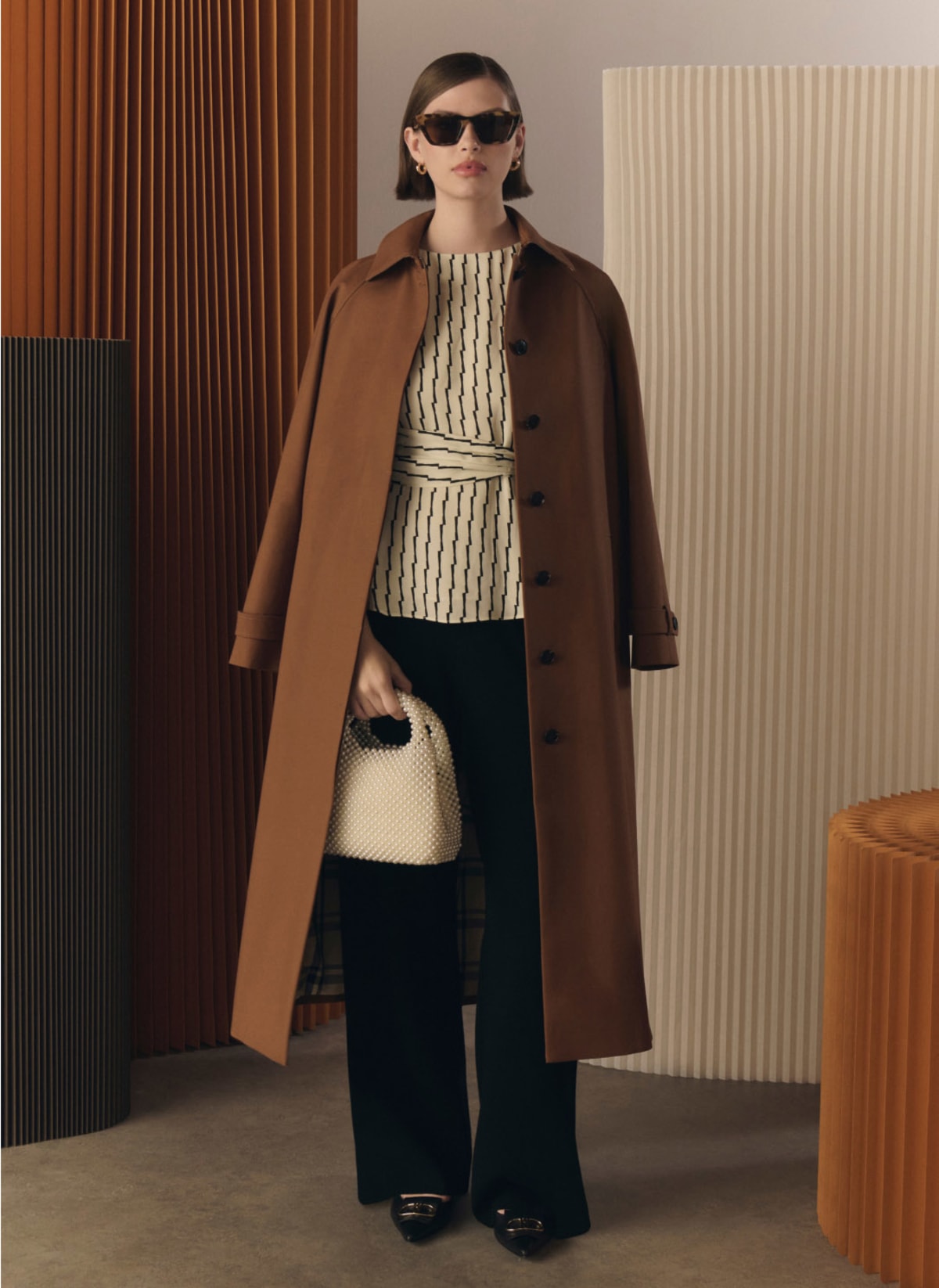 Model photographed in brown trench coat.