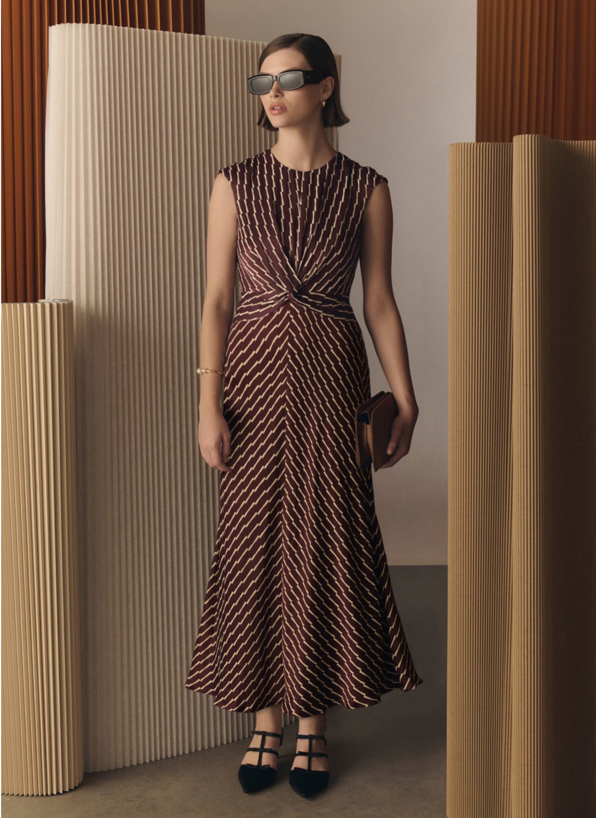 Model photographed in a brown dress.