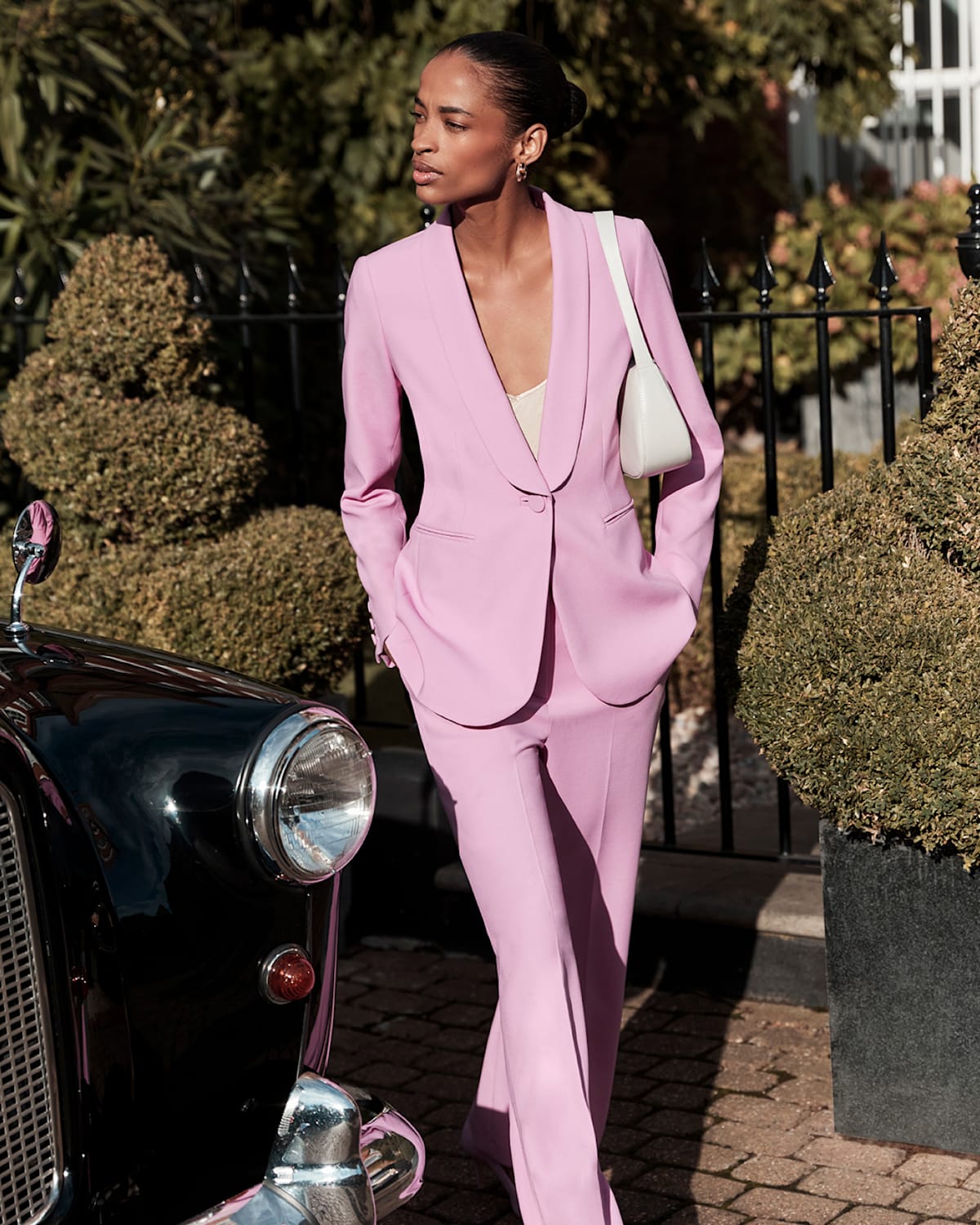 Hobbs model wears a contemporary pink suit with matching accessories.