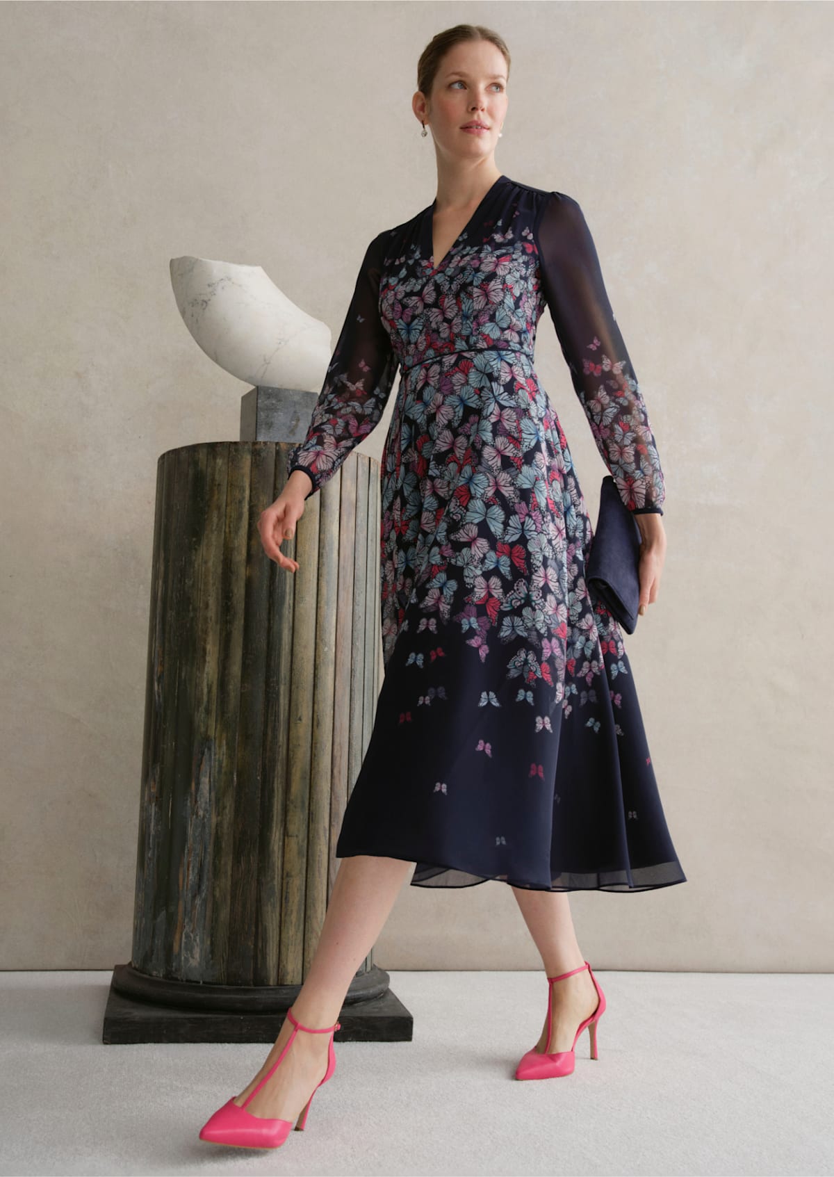 An image of a model wearing a navy occasion floral dress.